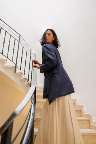 a woman in a blue coat walking down some stairs at Room Mate Oliveira - City Centre, Valencia in Valencia