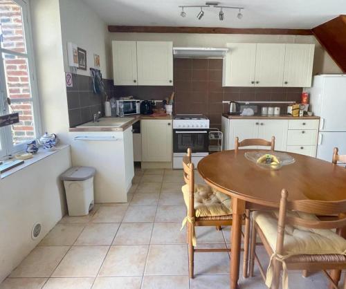 eine Küche mit einem Holztisch und Stühlen in der Unterkunft La Petite Maison in Saint-Dizier-Leyrenne