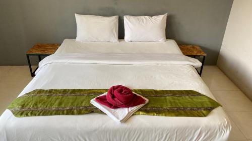a white bed with a red towel on it at Laemdin Hotel in Koh Samui 