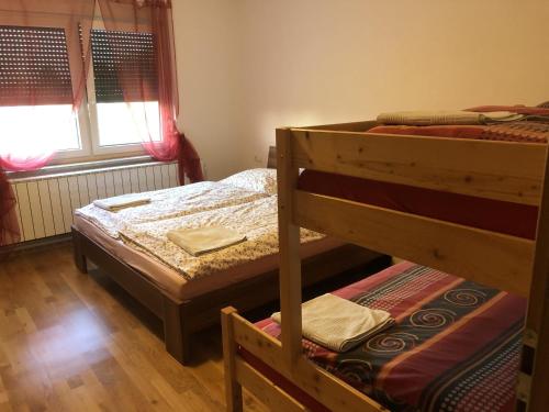 a bedroom with two bunk beds and a window at Prenočišča Kovač in Beltinci