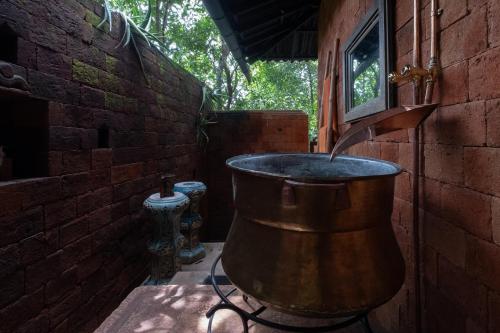 a large copper bucket sitting on a patio at Casa Heliconia in Gampaha