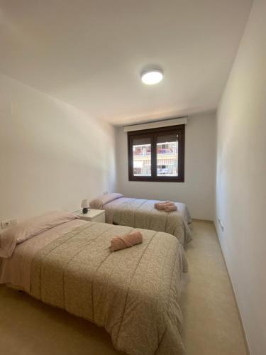 1 dormitorio con 3 camas y ventana en Mirador dels Terrers en Benicàssim