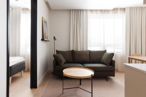 a living room with a couch and a table at Noli Herttoniemi in Helsinki