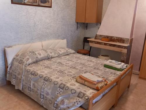 een slaapkamer met een bed met een deken en bagage erop bij casa Aurelia Ulassai 6 posti letto in Ulassai