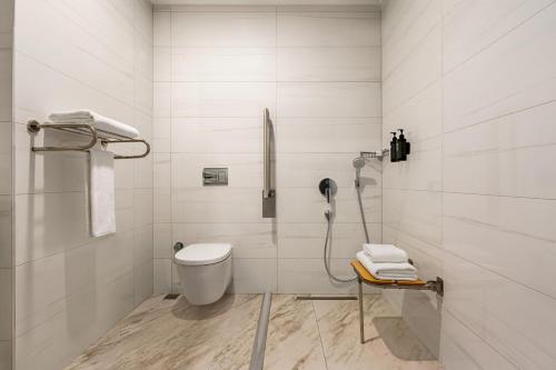 een witte badkamer met een toilet en een douche bij Ramada by Wyndham Istanbul Umraniye in Istanbul