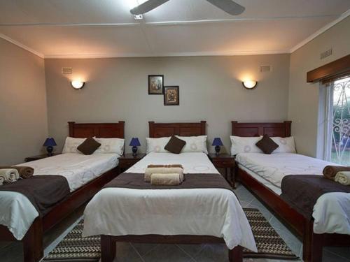 Кровать или кровати в номере Zambezi Family Lodge - Rhino Room
