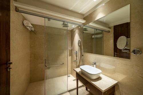 a bathroom with a glass shower and a sink at Country Inn Hall of Heritage, Amritsar in Amritsar