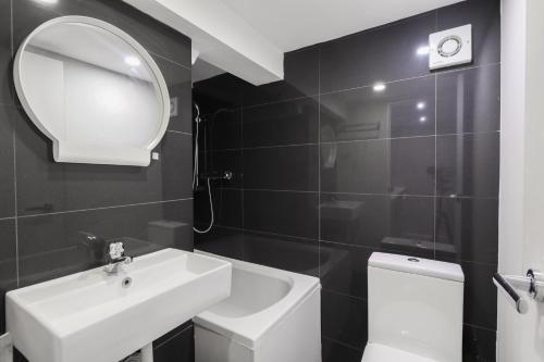 a bathroom with a sink and a mirror and a toilet at Unique single occupancy studio in London