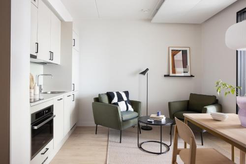 a kitchen and living room with a table and chairs at Noli Herttoniemi in Helsinki