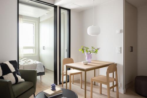 a living room with a dining room table and a mirror at Noli Herttoniemi in Helsinki