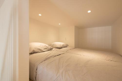 - une chambre avec un lit et 2 oreillers dans l'établissement SOFIA, appartement centre-ville, à Saint-Tropez