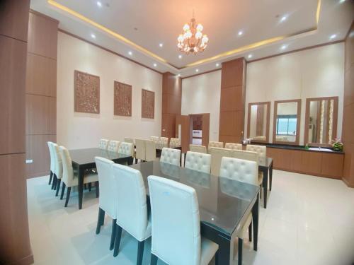 une salle à manger avec une table et des chaises blanches dans l'établissement BIDV HOTEL CỬA LÒ, à Dong Quan