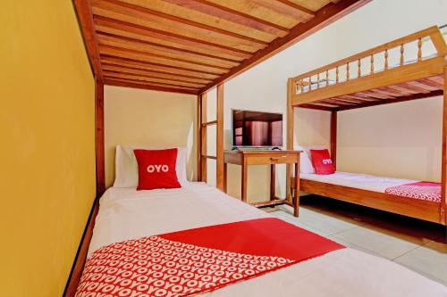 sypialnia z 2 łóżkami piętrowymi i czerwonymi poduszkami w obiekcie OYO 92912 Mtc Bunk Bed w mieście Salatiga