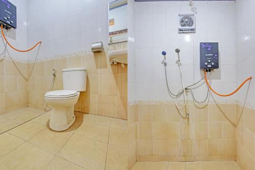 ein Bad mit einem WC und einer Dusche in der Unterkunft OYO 92912 Mtc Bunk Bed in Salatiga