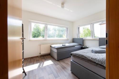 a bedroom with two beds and two windows at Stay & Work - 6 single beds - central in Emmerich