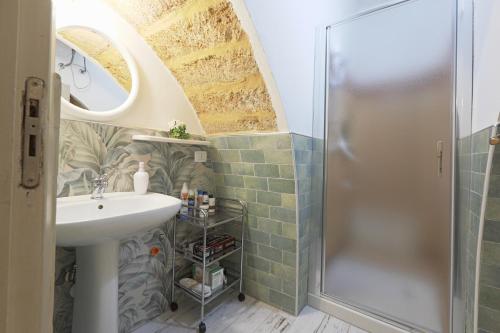 un baño con lavabo y ducha en La Sedia Rossa Historical Centre, en Agrigento