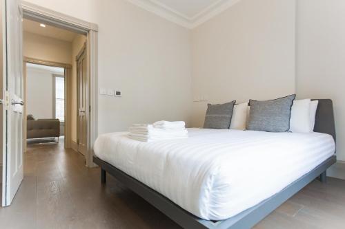 a bedroom with a large bed with white sheets and pillows at Soho Luxury 1 Bedroom Apartment by Concept Apartments in London