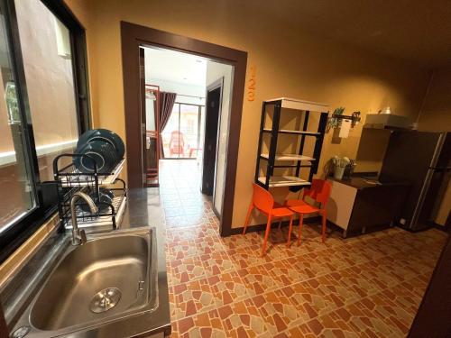 a kitchen with a sink and a table and chairs at My Friend's House Karon in Karon Beach