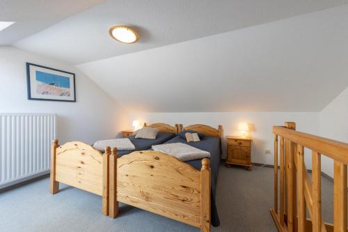 a bedroom with a wooden bed and a staircase at LM3-33 - Ferienwohnung Typ AB Komfort - a98967 in Schottwarden
