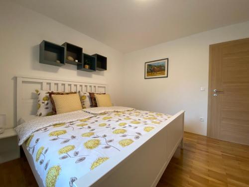 a bedroom with a bed with a yellow and white comforter at Karavanke Holiday Getaway in Hrušica