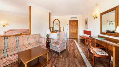 a living room with a couch and a piano at Hotel Serrano Palace in Cala Ratjada