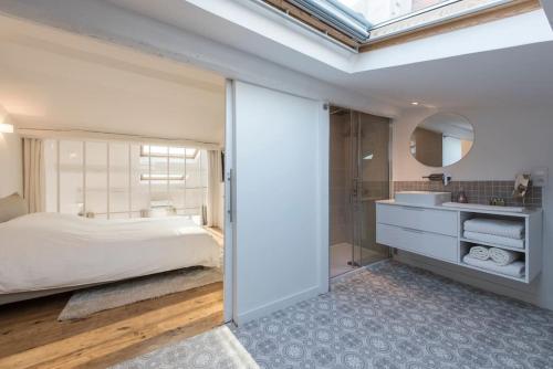une chambre avec un lit, un lavabo et un miroir dans l'établissement Duplex Cannes plein Centre, Zone Piétonne, 2 Chambres, à Cannes