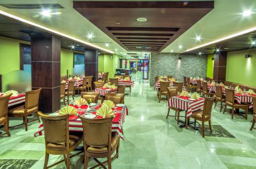 un restaurante con mesas y sillas en una habitación en Chirag Inn en Thiruvananthapuram