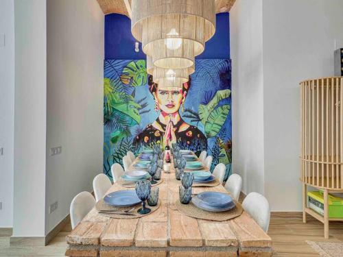 a table with a painting of a chef on the wall at Casa Mandarina: 4 Bedrooms - 2 Terraces - Parking in Hospitalet de Llobregat