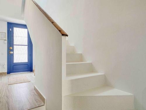a white staircase with a blue door in a room at Casa Mandarina: 4 Bedrooms - 2 Terraces - Parking in Hospitalet de Llobregat