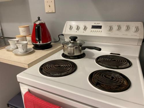 a white stove with a tea pot on top of it at The Cozy Hutt Home in Upper Hutt