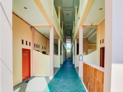 a corridor of a building with a blue floor at RedDoorz near Kantor Gubernur Kalimantan Tengah in Palangkaraya