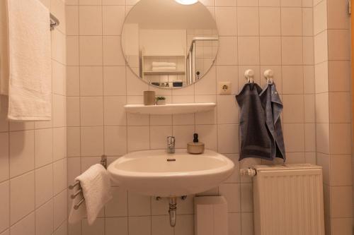 a white bathroom with a sink and a mirror at LM5-11 - Ferienwohnung Typ B Komfort in Schottwarden