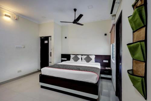 a bedroom with a bed and a ceiling fan at Townhouse Majestic Inn in Chennai