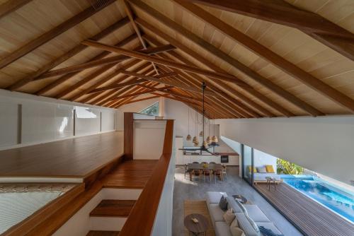 uma sala de estar com tectos em madeira e uma piscina em Villa Mia Fulhadhoo em Fulhadhoo