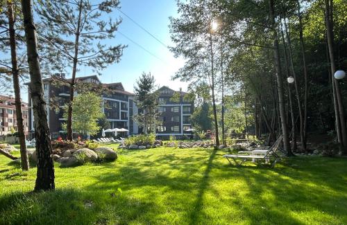 a park with a bench in front of a building at Predela 2 Aparthotel in Bansko