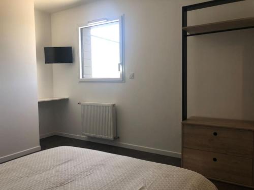 - une chambre avec un lit, une fenêtre et une commode dans l'établissement Location saisonnière Maen Roch, à Les Portes du Coglais