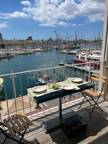 a table and chairs on a balcony with a marina at Marinca Port View Toulon in Toulon