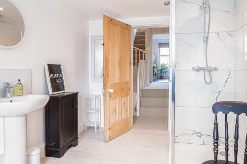 a bathroom with a shower and a sink and a door at Stunning Townhouse with Large Garden - Sleeps 8! in Cheltenham