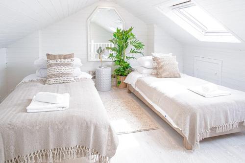 2 letti in una camera bianca con lucernario di Stunning Townhouse with Large Garden - Sleeps 8! a Cheltenham