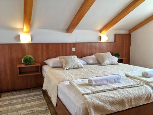 two beds in a bedroom with wooden walls and ceilings at Apartment Anima 3 in Klimno