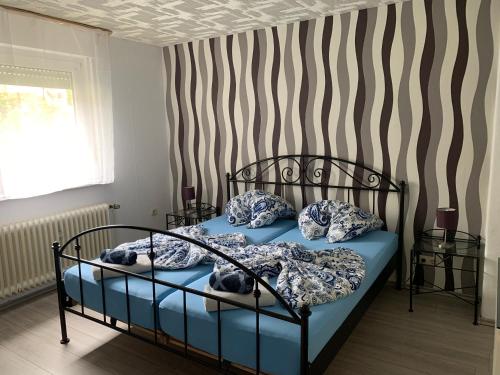 a bedroom with a bed with blue sheets and pillows at Birgeler Home in Birgel