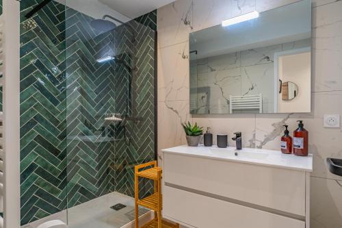 une salle de bain avec un lavabo et un miroir dans l'établissement Nathaniel - Appt terrasse 5 min de la plage, à Arcachon