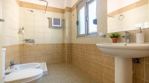 a bathroom with a sink and a toilet and a window at Stylish Extra - BIG 1+1 Central Apt in Himare