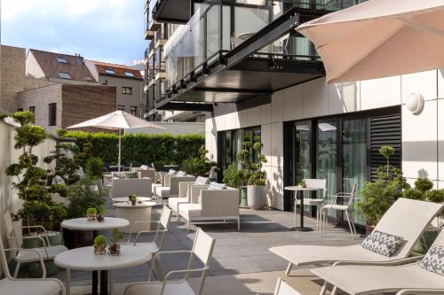 un patio avec des tables et des chaises dans un bâtiment dans l'établissement L-Avenue, à Bruxelles