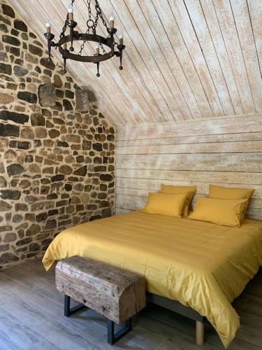 une chambre avec un lit dans un mur de briques dans l'établissement Domaine des Combes - La Ferme aux Anes 14 pers., à Millau