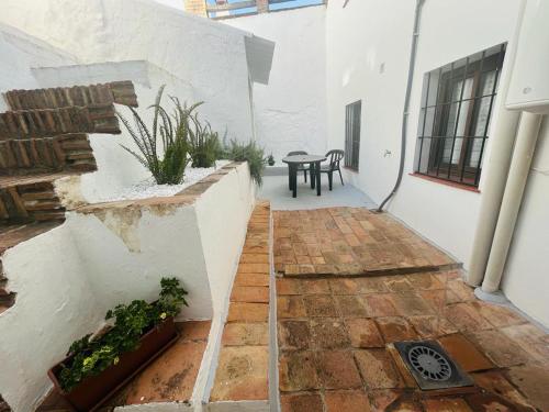 a courtyard of a house with a table and some plants at Casa Rural Doña Catalina in Jimena de la Frontera