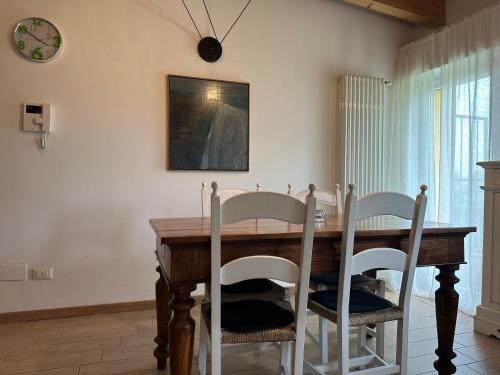 ミラノにあるLodi Houseのダイニングルームテーブル(椅子付)、壁掛け時計