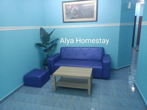ein Wohnzimmer mit einer blauen Couch und einem Couchtisch in der Unterkunft ALYA HOMESTAY TAMAN TAMBAK PAYA MURNI in Malakka