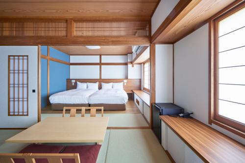 a bedroom with a bed and a table in a room at サザンシティホテル in Nankoku