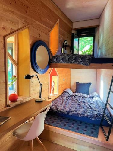 une chambre avec un lit, un bureau et une chaise dans l'établissement La Petite Maison du hÊtre, à Brassac